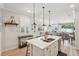 Bright kitchen features white cabinets, stainless appliances, large island with breakfast bar, and flows into dining and living rooms at 513 Harbor Springs Dr, Palm Harbor, FL 34683