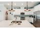Bright kitchen features white cabinets, tile backsplash, stainless steel appliances, and a large island with bar seating at 513 Harbor Springs Dr, Palm Harbor, FL 34683