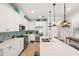 Bright kitchen features white cabinets, tile backsplash, stainless steel appliances, and a large island with breakfast bar at 513 Harbor Springs Dr, Palm Harbor, FL 34683
