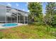 A private screened-in pool is surrounded by lush landscaping in a backyard setting at 5628 Terrain De Golf Dr, Lutz, FL 33558