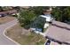 Aerial view of a cozy, single-story home with a dark roof, nestled between mature trees and a fenced backyard at 5698 26Th N Ave, St Petersburg, FL 33710
