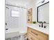 Updated bathroom boasts subway tile, modern vanity, and stylish black and white floor at 5698 26Th N Ave, St Petersburg, FL 33710