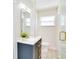 Updated bathroom with glass enclosed shower, blue vanity, and gold fixtures and hardware at 5698 26Th N Ave, St Petersburg, FL 33710