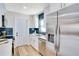 Renovated kitchen featuring white cabinets, stainless steel appliances, and blue tiled backsplash at 5698 26Th N Ave, St Petersburg, FL 33710
