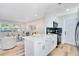 Open-concept kitchen with white cabinets, quartz countertops, an island, stainless steel appliances, and an adjoining living room at 5698 26Th N Ave, St Petersburg, FL 33710