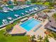 Aerial view of a community pool, marina, and clubhouse with boats docked nearby at 5964 Bayview S Cir, St Petersburg, FL 33707
