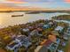 Aerial view of luxurious waterfront homes with docks and boats at sunset near the ocean at 5964 Bayview S Cir, St Petersburg, FL 33707