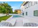 Inviting backyard pool area with lush landscaping, lounge chairs, and a modern home exterior at 5964 Bayview S Cir, St Petersburg, FL 33707