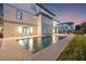 Outdoor pool at dusk, showcasing the well-lit modern home exterior and inviting patio space at 5964 Bayview S Cir, St Petersburg, FL 33707