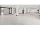 Large, open basement featuring epoxy floors, white columns, and garage doors for versatile space at 5964 Bayview S Cir, St Petersburg, FL 33707