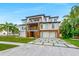 A modern home featuring multiple stories, balconies, two-car garage, palm trees, and a stylish driveway at 5964 Bayview S Cir, St Petersburg, FL 33707