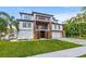 Beautiful home showcasing modern architecture, balconies, a two-car garage, and lush tropical landscaping at 5964 Bayview S Cir, St Petersburg, FL 33707