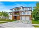 A modern home with balconies, two-car garage, and unique driveway design, framed by lush tropical landscaping at 5964 Bayview S Cir, St Petersburg, FL 33707