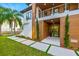 Modern home showcasing clean lines, wood accents, lush landscaping and paver walkway at 5964 Bayview S Cir, St Petersburg, FL 33707