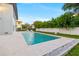 A pristine in-ground pool features a clean design with a large patio and manicured lawn at 5964 Bayview S Cir, St Petersburg, FL 33707