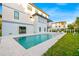 Beautiful backyard pool with white tiled patio, modern home exterior, and lush green grass at 5964 Bayview S Cir, St Petersburg, FL 33707