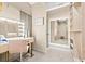 Walk-in closet with lighted vanity and framed mirror leading into a large, custom walk-in closet at 5964 Bayview S Cir, St Petersburg, FL 33707