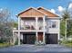 Two story home with a two car garage, front porch, and beautiful landscaping on a sunny day at 600 Banana St, Tarpon Springs, FL 34689