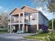 Two story home with a two car garage, front porch, and beautiful landscaping on a sunny day at 600 Banana St, Tarpon Springs, FL 34689