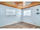 Bedroom with wood ceiling, light blue walls, and modern, wood-look flooring at 6118 Kracker Ave, Gibsonton, FL 33534