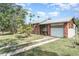 Cozy home showcasing a brick exterior, metal roof, and a convenient driveway at 6118 Kracker Ave, Gibsonton, FL 33534
