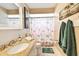 Bright bathroom featuring a granite countertop vanity, decorative shower curtain, and coordinated towels at 616 2Nd St, Indian Rocks Beach, FL 33785