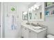 Bathroom with a marble countertop vanity, decorative turtle artwork, and ample lighting for a serene experience at 616 2Nd St, Indian Rocks Beach, FL 33785