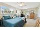 Bright bedroom featuring a large bed with a blue quilt, two windows, and a functional desk area at 616 2Nd St, Indian Rocks Beach, FL 33785