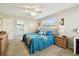 Comfortable bedroom with a blue bed, nightstand, and an ensuite bathroom, creating a relaxing retreat at 616 2Nd St, Indian Rocks Beach, FL 33785
