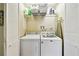 Functional laundry room featuring a washer, dryer, shelving for supplies, and space-saving bi-fold doors at 616 2Nd St, Indian Rocks Beach, FL 33785