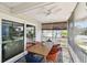 This covered porch includes outdoor dining table and chairs and screened windows at 616 2Nd St, Indian Rocks Beach, FL 33785