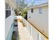 Well-maintained side yard with white fence, landscaping, and a walkway between homes at 616 2Nd St, Indian Rocks Beach, FL 33785