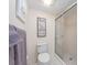 Close-up of bathroom showing the toilet and glass-enclosed shower, with decor adding a personal touch to the clean, white space at 640 Bayway Blvd # 302, Clearwater Beach, FL 33767