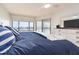 Bedroom featuring blue bedding, wood floors, and a view of the bay from the window at 640 Bayway Blvd # 302, Clearwater Beach, FL 33767