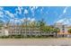 Full exterior view of the condominium complex with multiple balconies, a street view and a landscaped median at 640 Bayway Blvd # 302, Clearwater Beach, FL 33767