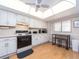 Bright kitchen featuring white cabinets, sleek black appliances, and a ceiling fan at 640 Bayway Blvd # 302, Clearwater Beach, FL 33767
