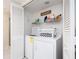 Efficient laundry room with a washer and dryer, shelving, and a compact design for easy access and storage of supplies at 640 Bayway Blvd # 302, Clearwater Beach, FL 33767