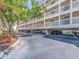 Exterior view of a condominium complex showing the covered parking area and manicured landscaping at 640 Bayway Blvd # 302, Clearwater Beach, FL 33767