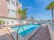Inviting pool area with clear blue water, surrounded by brick pavers, palm trees, and lounge chairs for a relaxing outdoor experience at 640 Bayway Blvd # 302, Clearwater Beach, FL 33767
