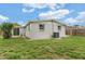 Expansive backyard featuring green grass and a white painted block home at 6612 W Chelsea St, Tampa, FL 33634
