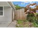This backyard features a wooden gate and some shade trees at 6612 W Chelsea St, Tampa, FL 33634