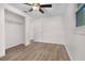 Bright bedroom features wood-look flooring, a ceiling fan, and a closet at 6612 W Chelsea St, Tampa, FL 33634