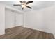 A bright, minimalist bedroom with neutral walls, wood-look flooring, and a ceiling fan for added comfort at 6612 W Chelsea St, Tampa, FL 33634