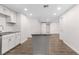 Spacious kitchen featuring a kitchen island, white cabinets, recessed lighting, and wood-look flooring at 6612 W Chelsea St, Tampa, FL 33634