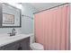 Cozy bathroom featuring modern vanity, toilet, and shower with a stylish pink curtain at 7201 5Th N Ave, St Petersburg, FL 33710