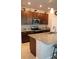 Modern kitchen with stainless steel appliances, granite countertops, and dark wood cabinets at 8009 Trimbelle Ter, Parrish, FL 34219