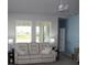 Bright living room with white sofa, large windows, and neutral paint at 8009 Trimbelle Ter, Parrish, FL 34219