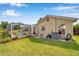 This is a view of the large back yard with green grass and showing the back of the house, screened-in lanai, and air conditioner at 815 Sandy Trail Pl, Brandon, FL 33511