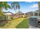Well maintained back yard, showing the fence line, screened-in lanai, tall palm tree, and the air conditioner at 815 Sandy Trail Pl, Brandon, FL 33511
