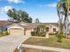 Charming single-story home with a well-manicured front lawn, mature trees, and a two-car garage at 815 Sandy Trail Pl, Brandon, FL 33511